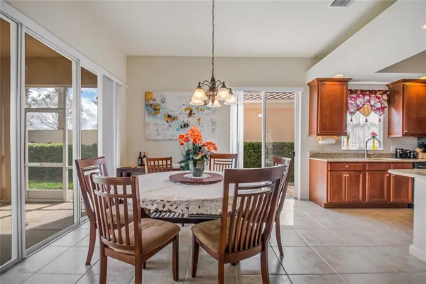 a view of a dining room with furniture a chandelier and wooden floor