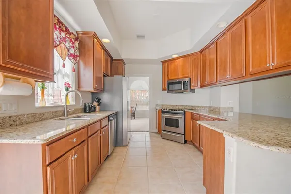 a kitchen with stainless steel appliances granite countertop a sink stove and refrigerator