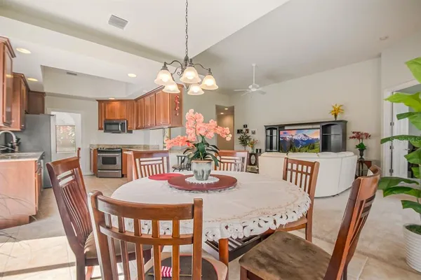 a view of a dining room with furniture a chandelier and wooden floor