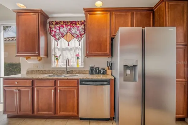 a kitchen with stainless steel appliances granite countertop a refrigerator and a sink