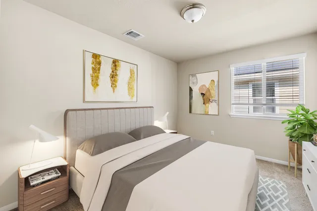 a bedroom with a bed and a potted plant