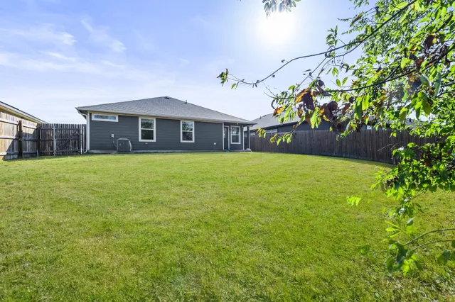a view of a house with a yard and potted plants