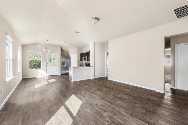 a view of a kitchen with wooden floor and a refrigerator