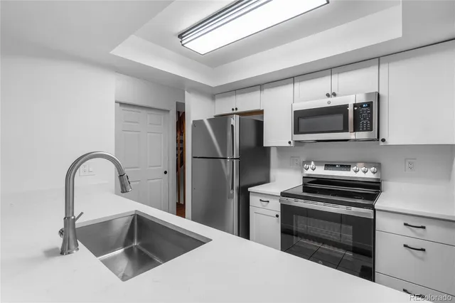 a kitchen with a refrigerator and a stove top oven