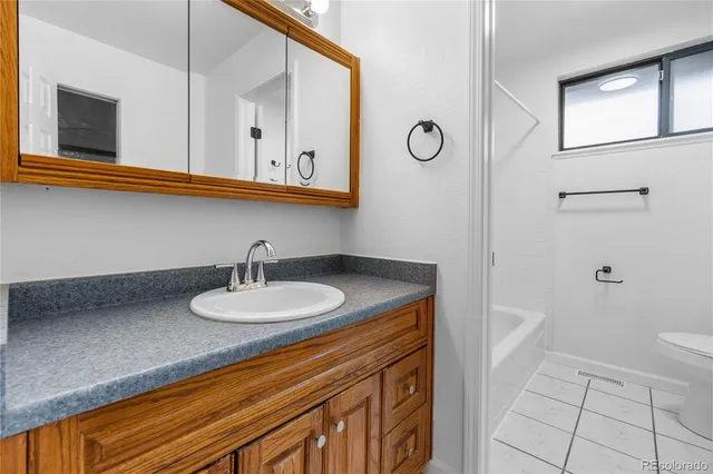 a bathroom with a sink a toilet and mirror