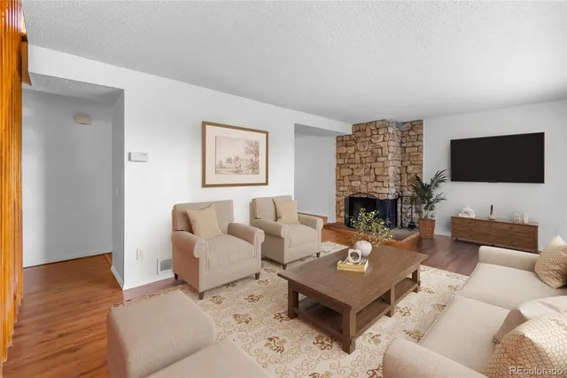 a living room with furniture a flat screen tv and a fireplace