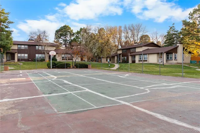 a view of a big building with a big yard and large trees