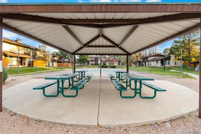 a view of a house with a park bench and a wooden bench