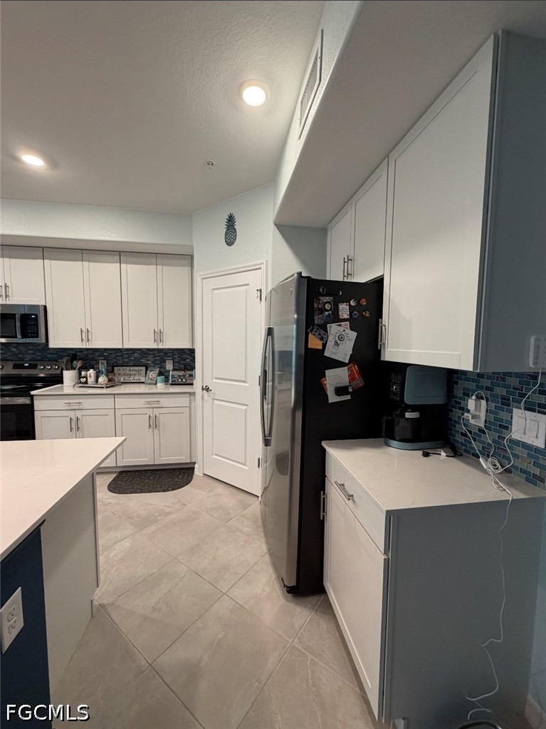 14191 Poppy Fld Loop, Unit 5312 Punta Gorda, FL 33955 - Photo 10 of 41 a kitchen with a sink a refrigerator and white cabinets
