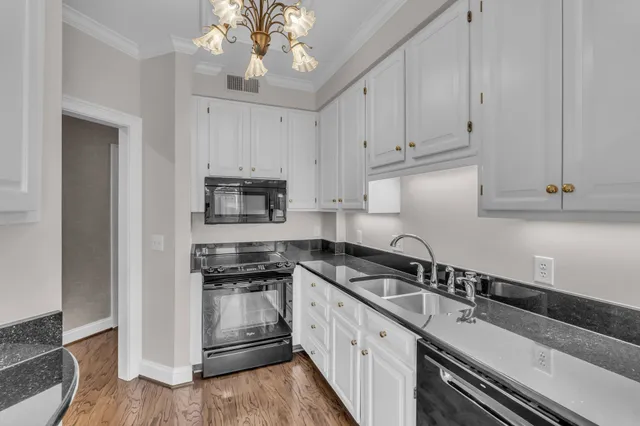 a kitchen with granite countertop a sink stainless steel appliances and cabinets