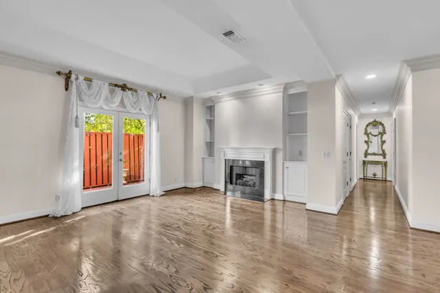 a view of an empty room with a fireplace and a window