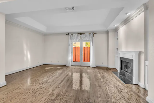 an empty room with windows and fireplace