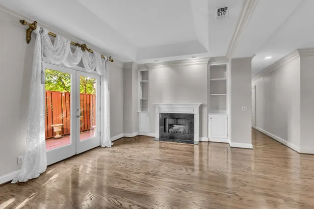 a view of an empty room with a fireplace and a window