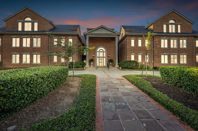 a front view of a house with a yard and garden