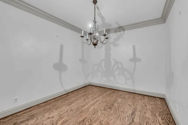 a view of a room with wooden floor and chandelier