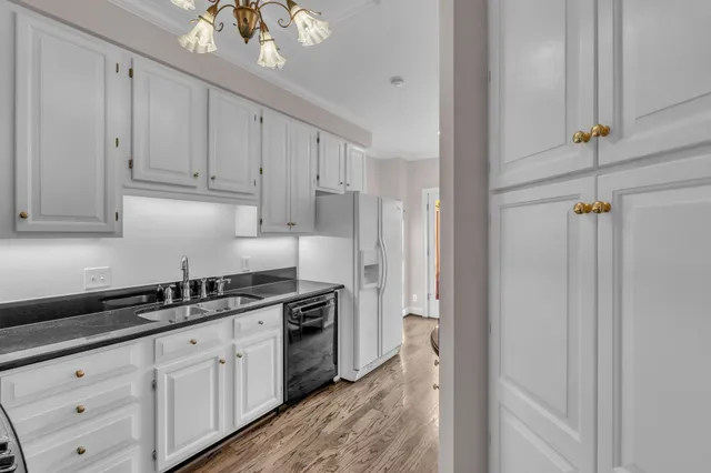 a kitchen with white cabinets and sink
