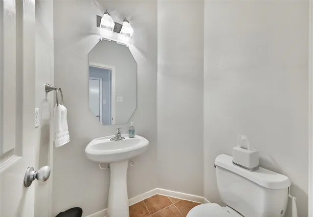 a bathroom with a sink toilet and a mirror