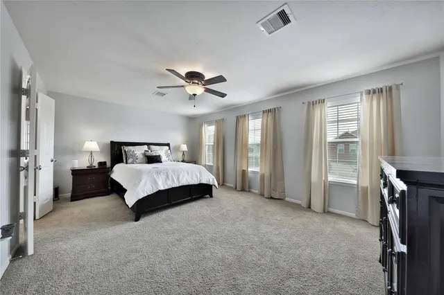 a spacious bedroom with a bed and a chandelier