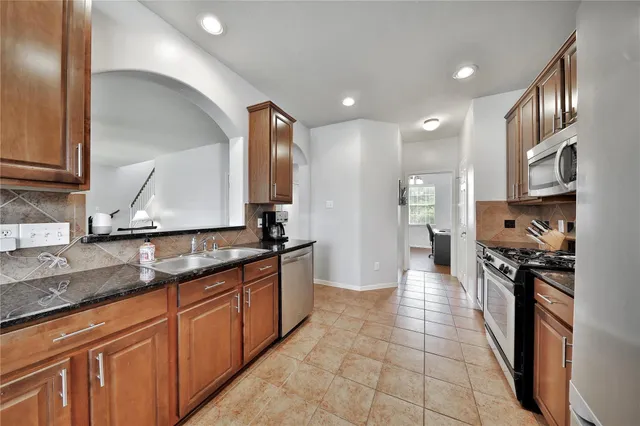 a large kitchen with stainless steel appliances granite countertop a sink and cabinets