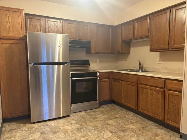 a kitchen with a refrigerator sink and cabinets