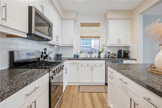 a kitchen with stainless steel appliances granite countertop a sink stove microwave and cabinets