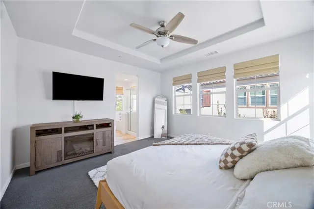 a spacious bedroom with a bed and a flat screen tv