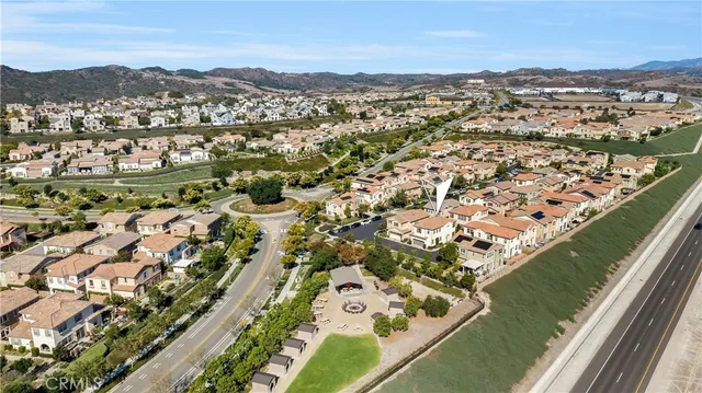 an aerial view of residential houses with outdoor space and trees