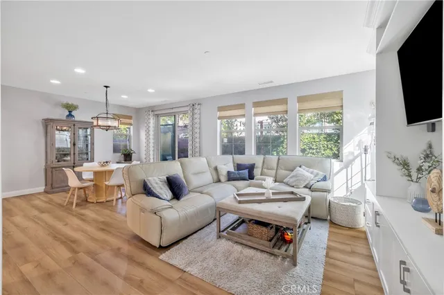 a living room with furniture flat screen tv and a large window