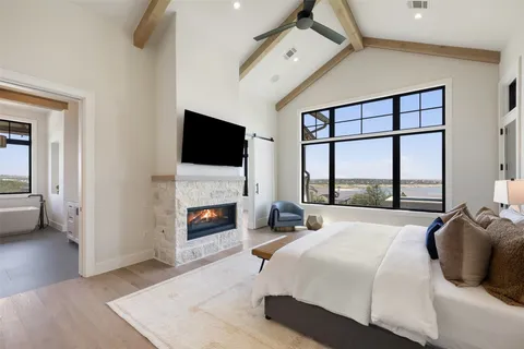 a bedroom with a bed a fireplace and a large window
