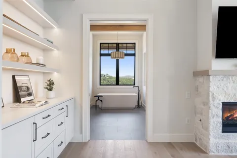 a bathroom with a tub a sink and a large mirror