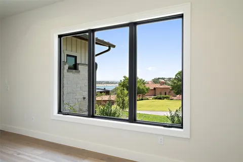 an empty room with wooden floor and a porch
