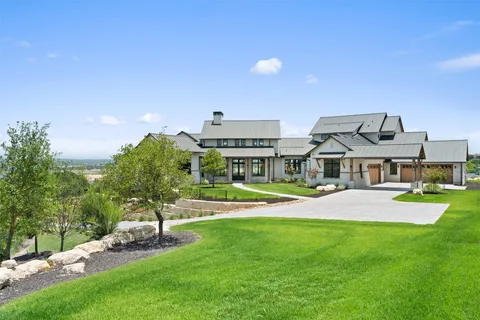a view of a house with a big yard and potted plants
