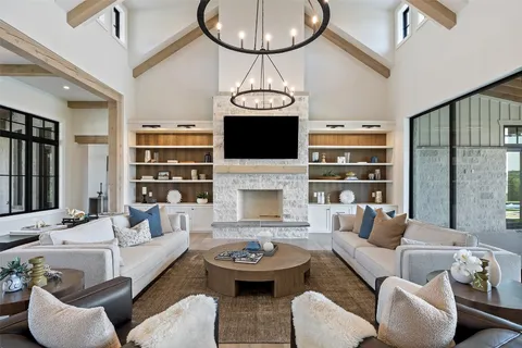a living room with furniture a fireplace and a chandelier