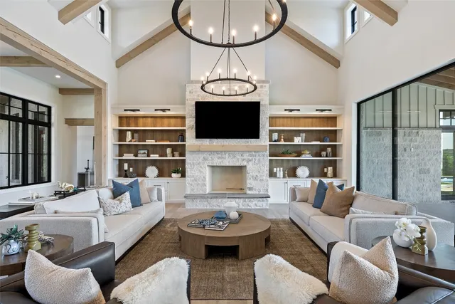 a living room with furniture a fireplace and a chandelier