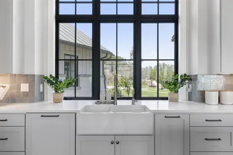 a kitchen with a large window sink and cabinets