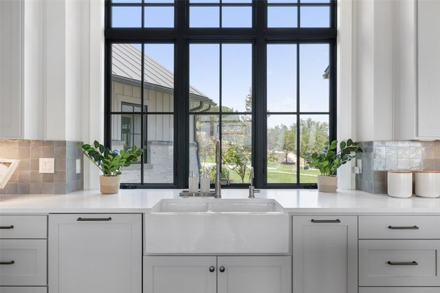 a kitchen with a large window sink and cabinets