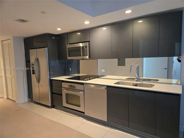 a kitchen with a sink stainless steel appliances and cabinets
