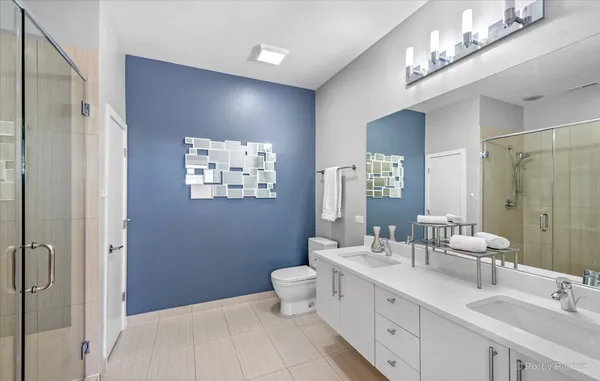 a bathroom with a double vanity sink toilet and shower