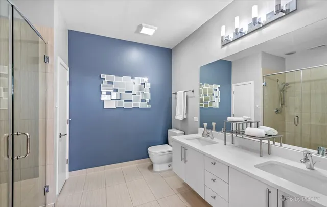 a bathroom with a double vanity sink toilet and shower