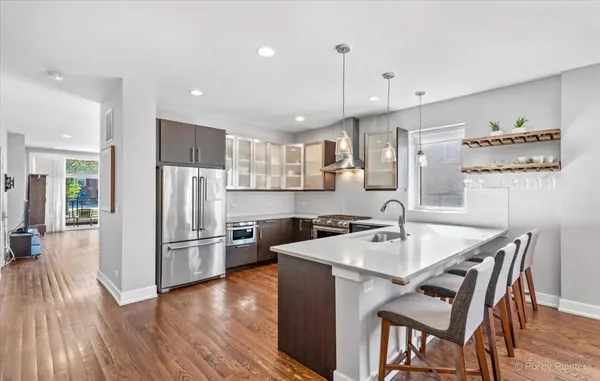 a kitchen with refrigerator cabinets dining table and chairs