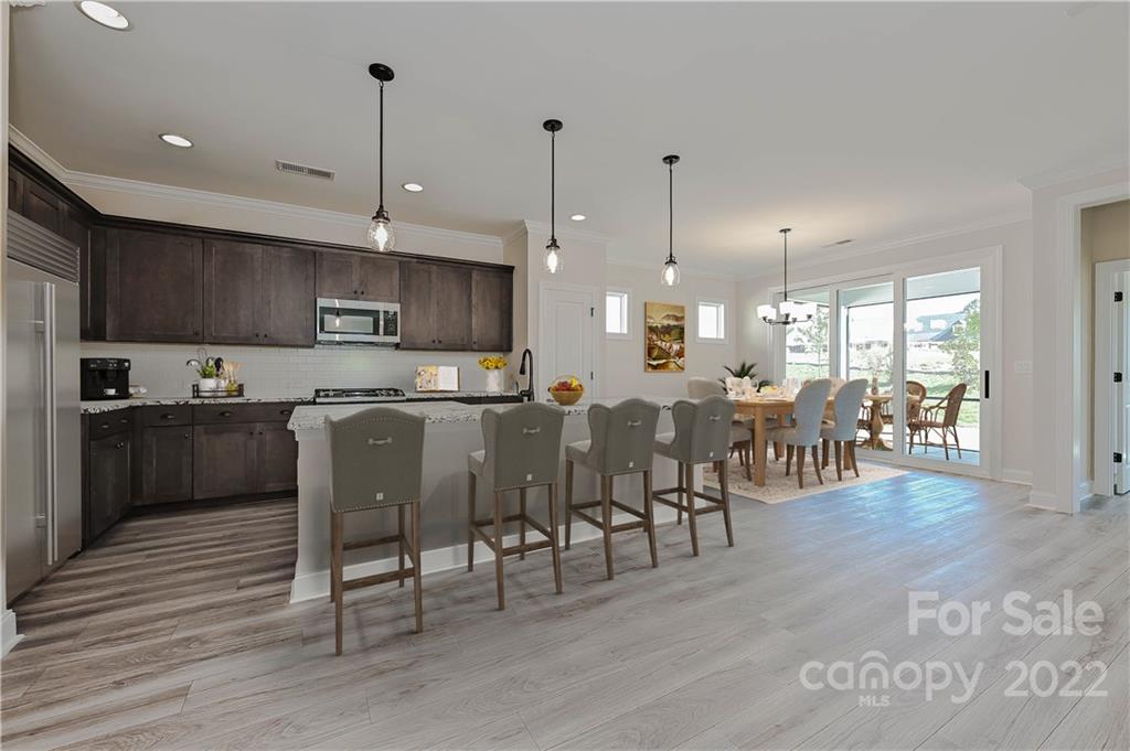 6136 Pier Drive, Unit 1139 Denver, NC 28037 - Photo 2 of 12 a kitchen with lots of wooden furniture appliances and a center island