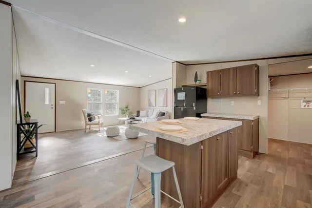 a living room with stainless steel appliances kitchen island granite countertop furniture and a kitchen view