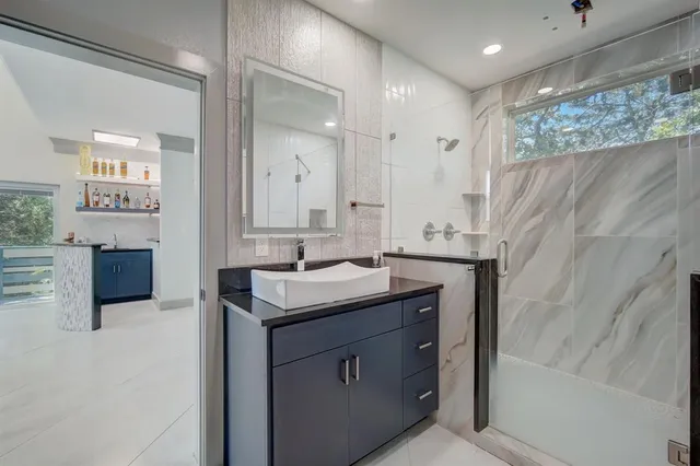 a bathroom with a sink a mirror and a shower