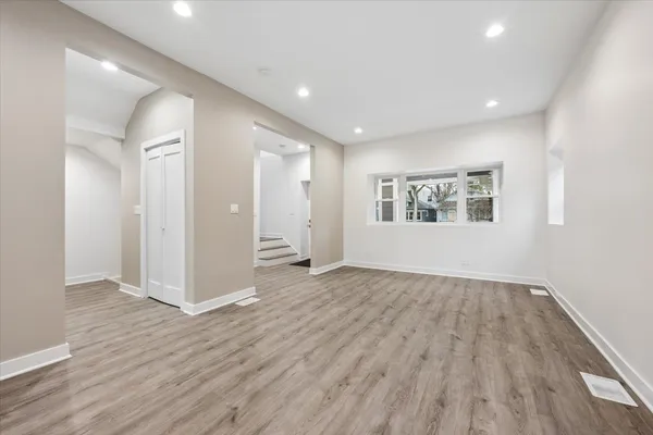 a view of a big room with wooden floor and windows