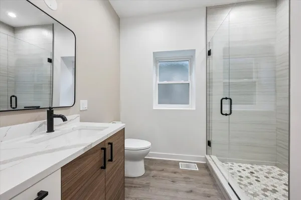 a bathroom with a sink a toilet and shower