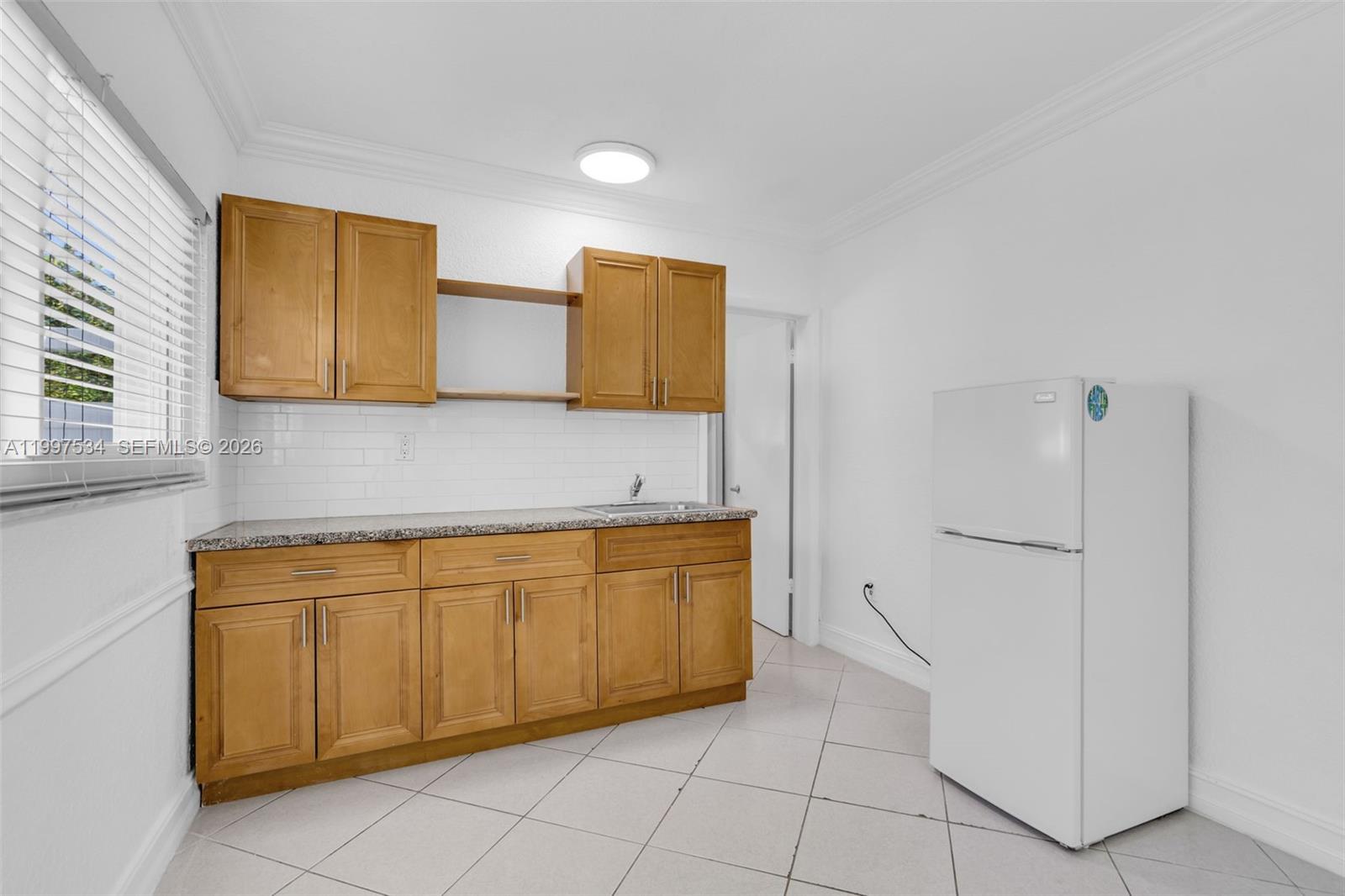 201 Southwest 51st Court, Unit 3 Miami, FL 33134 - Photo 4 of 6 a kitchen with a refrigerator and cabinets