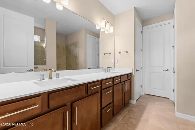 a spacious bathroom with a double vanity sink and a mirror