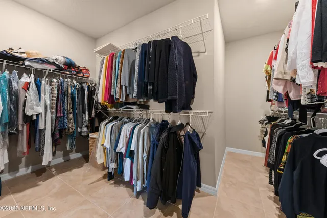 a view of walk in closet with clothes