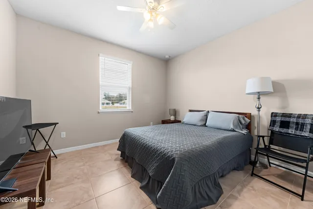 a bedroom with a bed a chair and a chandelier