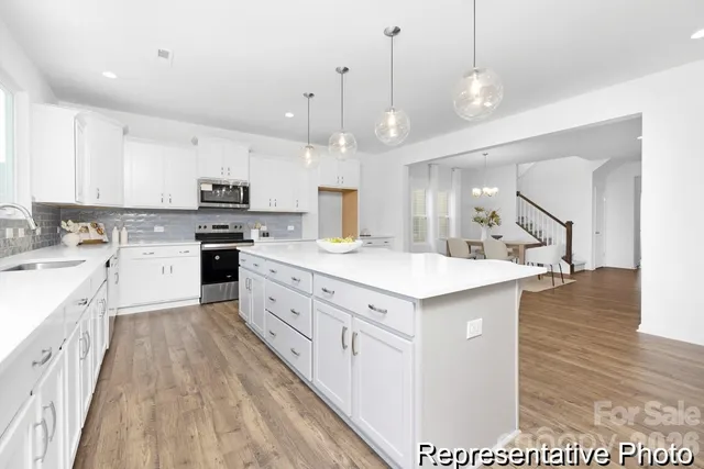 a large kitchen with kitchen island a sink a center island and stainless steel appliances